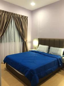 a bedroom with a blue bed with a window at Meena's Apartment @ The Quintet in Cameron Highlands