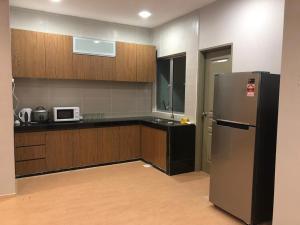 a kitchen with a refrigerator and a microwave at Meena's Apartment @ The Quintet in Cameron Highlands
