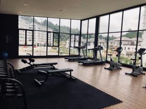 a gym with a bunch of tread machines in a room with windows at Meena's Apartment @ The Quintet in Cameron Highlands +10 photos
