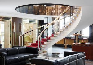 a living room filled with furniture and a stair case at Living Hotel Kanzler in Bonn