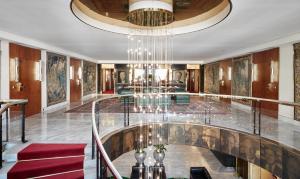 a lobby with a glass floor and a chandelier at Living Hotel Kanzler in Bonn
