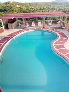 uma piscina com um gazebo e água azul em Angel del Mar em Puerto Ángel