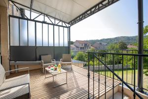 a screened in porch with a table and chairs on a balcony at Le Gîte de Siloe in Villefranche-de-Rouergue