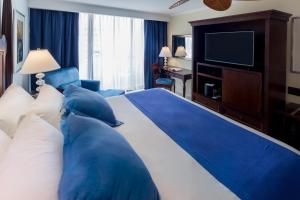 a hotel room with a large bed with blue pillows at Barceló Aruba - All Inclusive in Palm-Eagle Beach