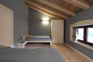 a bedroom with a bed and a window at Zoncolan Apartments in Sùtrio