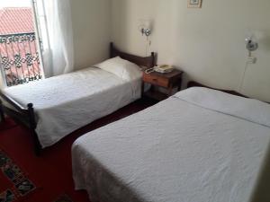 a small room with two beds and a window at Pensao Residencial Mirasol in Funchal