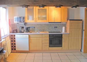a kitchen with wooden cabinets and a white appliance at Santa Maria in Nettersheim