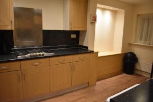 a kitchen with wooden cabinets and a counter top at Home From Home in Bristol