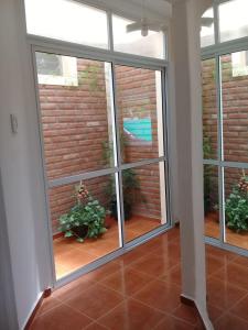 a room with a large glass window with plants at La casita de Chany in Mina Clavero