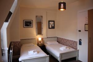 2 camas en una habitación con escalera en Ardmillan Hotel, en Edimburgo