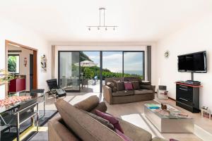 een woonkamer met een bank en een tv bij OurMadeira - The Designhouse, contemporary in Arco da Calheta