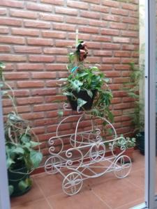 a plant holder in front of a brick wall at La casita de Chany in Mina Clavero