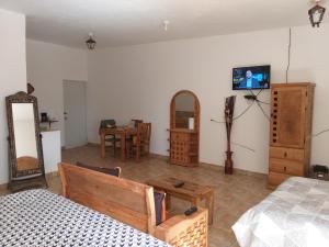 um quarto com uma cama e uma televisão na parede em Hotel Villas Monteli Suites Cuernavaca em Cuernavaca