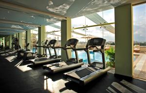 a row of treadmills in a gym with a pool at Taj Club House in Chennai