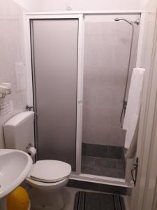 a bathroom with a shower with a toilet and a sink at Pensao Residencial Mirasol in Funchal