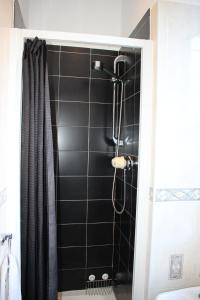 a shower in a bathroom with a black tiled wall at Ardmillan Hotel in Edinburgh