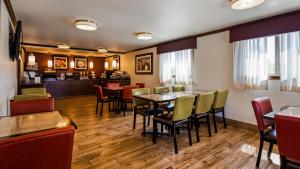 a restaurant with tables and chairs and a bar at Best Western Paradise Inn in Dillon