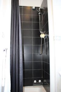 y baño con ducha y pared de azulejos negros. en Ardmillan Hotel, en Edimburgo