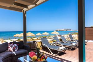 a patio with lounge chairs and the beach at Espera, Luxury Beach Front Residence, By ThinkVilla in Rethymno