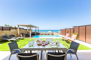 a table with food on it next to a swimming pool at Espera, Luxury Beach Front Residence, By ThinkVilla in Rethymno