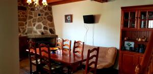 オヨス・デル・エスピーノにあるCasa Rural Tío Carlillosのダイニングルーム(テーブル、椅子、ソファ付)