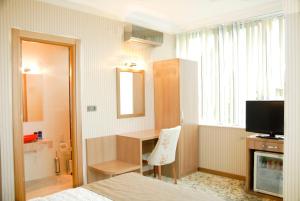 Zimmer mit einem Bett, einem Schreibtisch und einem TV in der Unterkunft Lounge Hotel in Tuzla