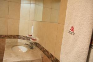 La salle de bains est pourvue d'un lavabo sur un mur carrelé. dans l'établissement Hotel Azucena, à Huamantla