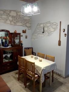 une salle à manger avec une table et des chaises blanches dans l'établissement Petra Guest House, à Áyiai Paraskiaí