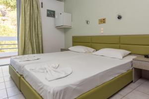 a bedroom with a large bed with white sheets at Megim Hotel in Palaiochora