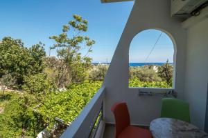 a room with a balcony with a view of the ocean at Megim Hotel in Palaiochora