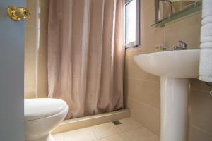 a bathroom with a sink and a toilet and a shower at Megim Hotel in Palaiochora
