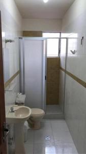 a bathroom with a shower and a toilet and a sink at Hostal Jem in Cochabamba