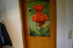 a door with a painting of red flowers on it at Hamburg-Rahlstedt, klein aber sehr fein, ILS-nah in Hamburg
