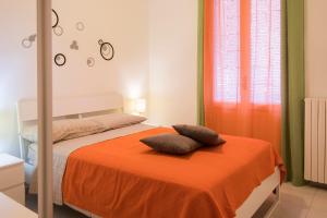 ein Schlafzimmer mit einem Bett mit einer orangefarbenen Decke in der Unterkunft Casa Gaby in Rom