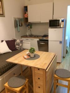 een kleine keuken met een tafel in een kleine kamer bij VERY CLOSE Studio Apartment in Zagreb