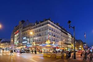 a large building on a city street at night at New Hôtel Gare Du Nord in Paris