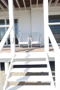two white chairs sitting on the porch of a house at Thyme & Tide Beach Villa in Yzerfontein
