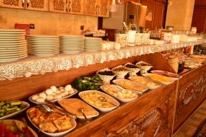 a buffet line with dishes of food and plates at Cappadocia Elite Stone House in Goreme