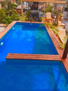 uma piscina com um deque de madeira e água azul em Hotel Central em Tarapoto