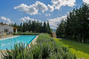 a swimming pool in a yard next to a grass field at Il Verreno in Bucine
