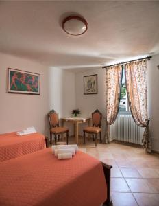 a bedroom with two beds and a table and chairs at da Barbara in Orco Feglino