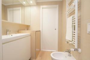 W białej łazience znajduje się umywalka i lustro. w obiekcie Luxury and spacious apartment (Bocconi) w Mediolanie