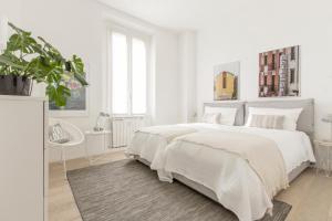 a white bedroom with a large bed and a rug at Luxury and spacious apartment (Bocconi) in Milan