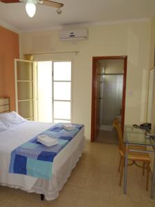 a bedroom with a bed and a glass table at Itália Hotel in Fernandópolis