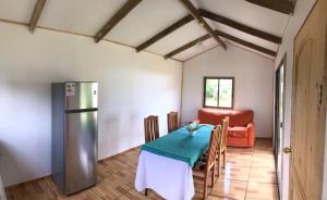 a kitchen with a table and a refrigerator at HARÉ MANU Rapa Nui in Hanga Roa