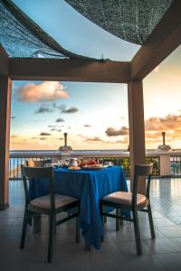 a dining table with a blue tablecloth and chairs on a balcony at Abuharee Grand in Hithadhoo