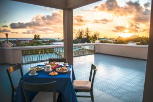 a table with food on a balcony with the sunset at Abuharee Grand in Hithadhoo