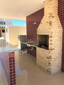 a brick fireplace in the middle of a room at Nosso Lar-Ap Rio das Ostras in Rio das Ostras