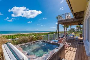 a hot tub on the balcony of a house with the beach at Bella Vista in Fort Pierce