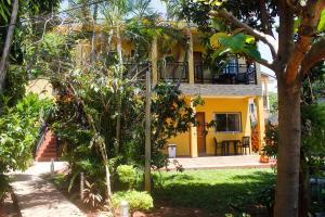 a yellow house with a balcony in a yard at Hospedaje Jose Gorgues in Puerto Iguazú